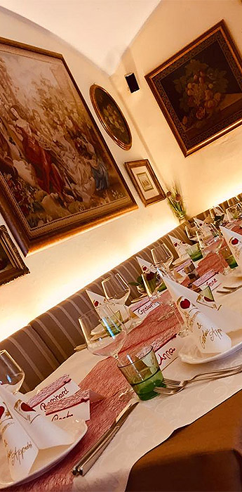 Wir freuen uns auf Ihren Besuch Ein gedeckter Tisch mit Besteck, Tellern, Gläsern und Servietten